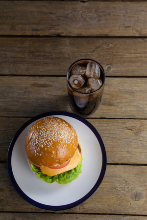 Overhead of hamburger in plate with glass of cold drinkの写真素材