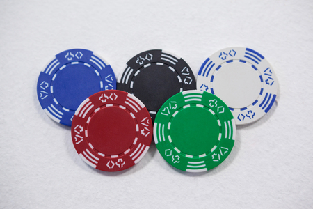 Various casino chips arranged on white background