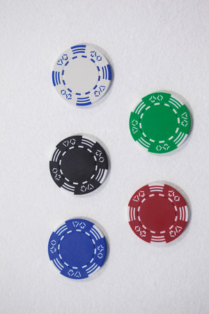 Various casino chips arranged on white background