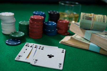 Close-up of whisky and money during poker game on green tableの写真素材