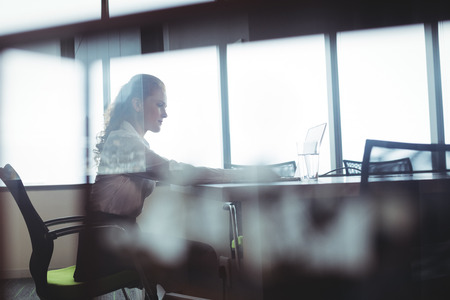 Side view of businesswoman sitting at office cafeteria
