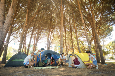 Friends camping on field at campsiteの写真素材