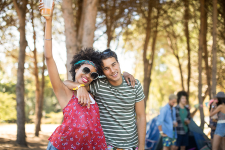 Portrait of happy young friends standing together at campsiteの写真素材