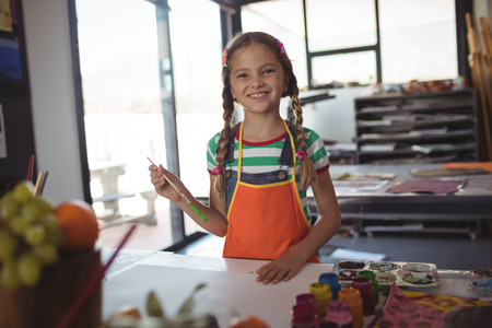 Portrait of smiling girl standing at painting class