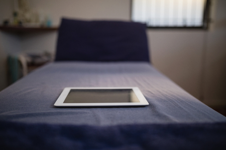 Close-up of digital tablet on blue bed in hospitalの写真素材