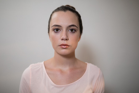 Close-up portrait of young female therapist against wall at hospital wardの写真素材