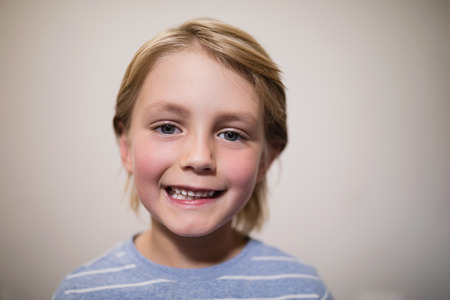 Close-up portrait of smiling boy against wall at hospital wardの写真素材