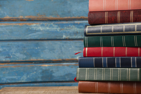 Stack of books against blue wooden backgroundの写真素材