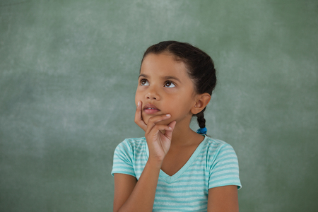 Thoughtful young girl against chalk boardの写真素材