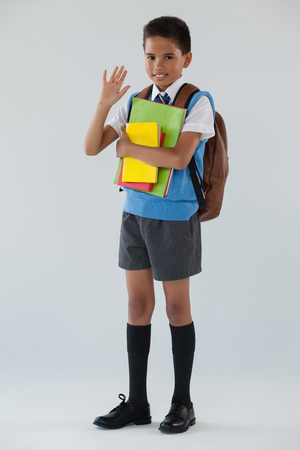 Portrait of schoolboy in school uniform with school bag on white backgroundの写真素材