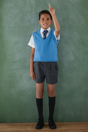 Schoolboy raising hand in classroom at schoolの写真素材