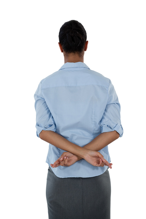 Rear view of businesswoman holding her fingers crossed behind her backの写真素材
