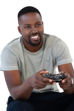Smiling man playing video game against white backgroundの写真素材