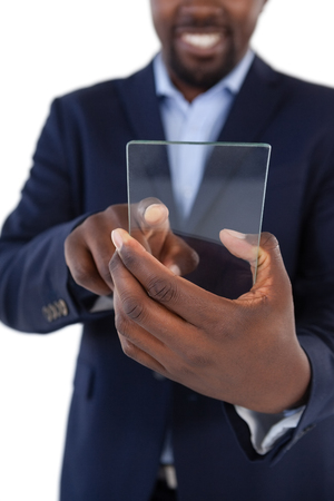 Mid section of businessman holding a glass smartphoneの写真素材