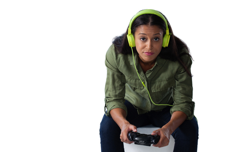 Portrait of woman playing video game against white backgroundの写真素材