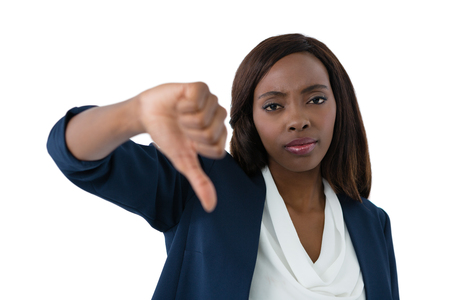 Close up portrait of businesswoman showing thumbs down against white backgroundの写真素材