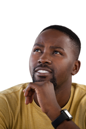 Thoughtful man with hand on chin against white backgroundの写真素材