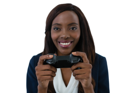 Close up of smiling businesswoman playing video game against white backgroundの写真素材