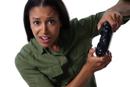 Portrait of woman making funny faces while playing video gamesの写真素材