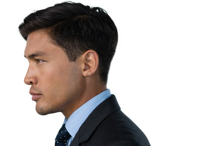 Side view of businessman looking away against white backgroundの写真素材