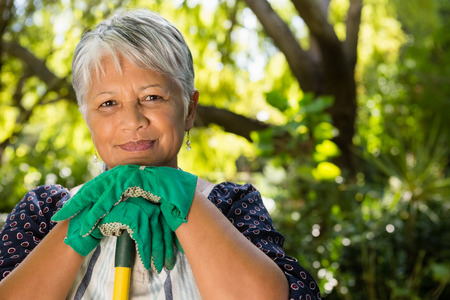 Portrait of senior woman standing in garden on a sunny day
