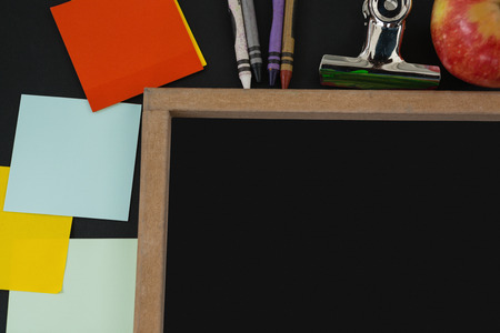 Close-up of blank slate with various school supplies on black backgroundの写真素材