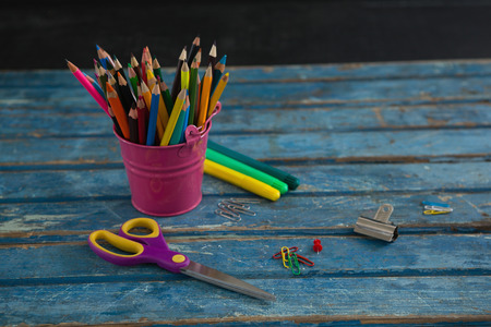 Various school supplies on wooden table against black background