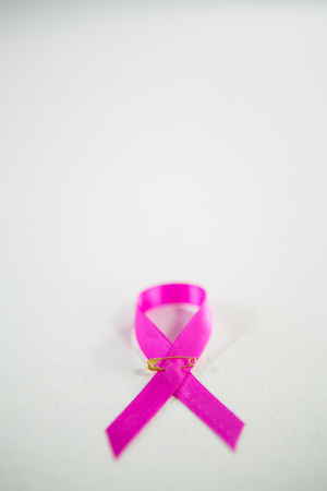 Close-up of pink Breast Cancer Awareness ribbon on white backgroundの写真素材