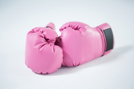 Close-up of pink boxing gloves on white backgroundの写真素材