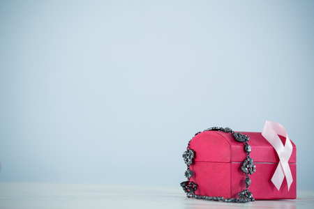 Pink Breast Cancer Awareness ribbon and jewelry on red box against gray backgroundの写真素材