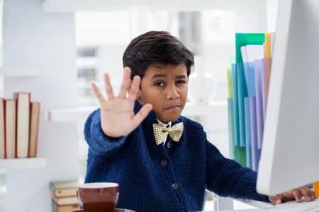 Portrait of businessman showing hand while sitting at desk in office
