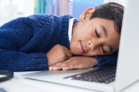 Close up of businessman sleeping on laptop at desk in officce
