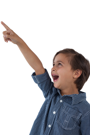 Cute boy pointing finger against white backgroundの写真素材