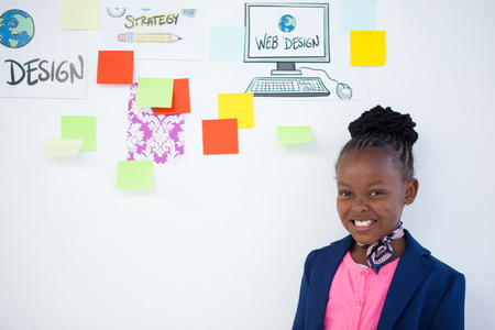 Portrait of cheerful businesswoman standing against sticky notes on whiteboardの写真素材