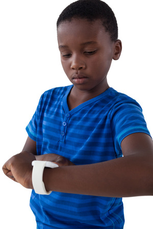 Cute boy operating his smart watch against white backgroundの写真素材
