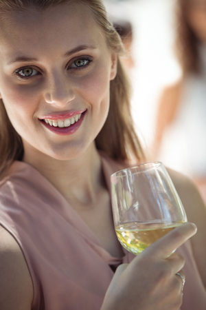 Portrait of smiling woman holding glass of wine in restaurantの写真素材