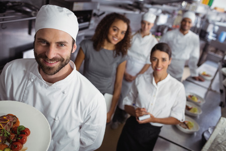 Portrait of restaurant manager with his kitchen staff in the commercial kitchenの写真素材
