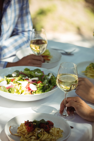 Close-up of food and wine glass on dining table in restaurantの写真素材