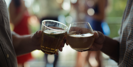 Mid-section of male friends toasting cocktail glasses in restaurantの写真素材