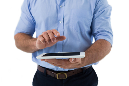 Mid section of male executive using digital tablet against white backgroundの写真素材