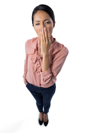 Portrait of female executive yawning on white backgroundの写真素材