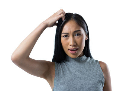 Confused woman standing against white backgroundの写真素材