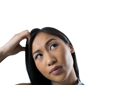 Confused woman standing against white backgroundの写真素材
