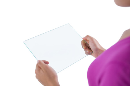 Mid-section of girl using glass digital tablet against white backgroundの写真素材