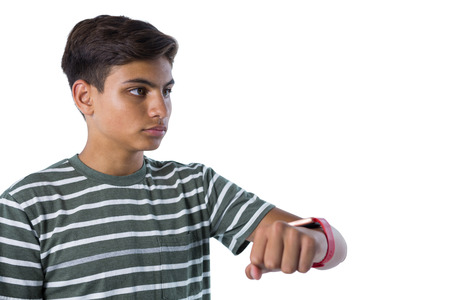 Teenage boy looking at his smartwatch against white background