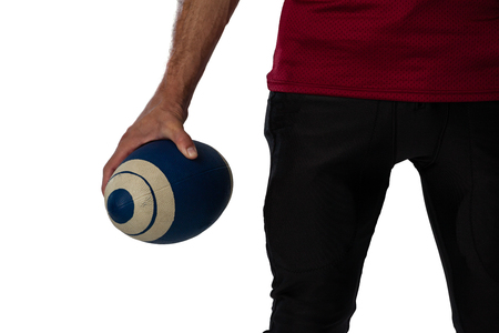Cropped image of football player holding ball against white backgroundの写真素材