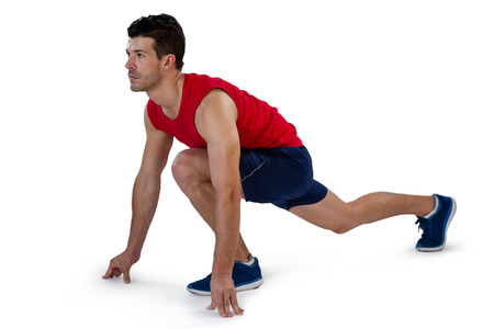 Concentrated sports player in running position against white background