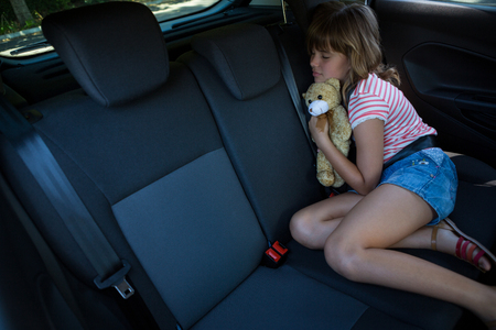 Cute teenage girl sleeping in the back seat of carの写真素材