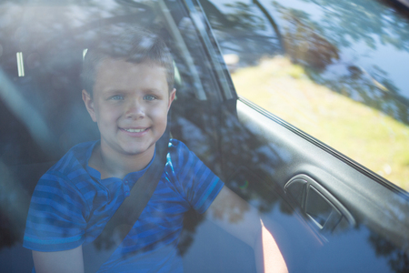 Portrait of teenage boy sitting in the front seat of carの写真素材