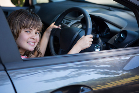 Portrait of happy teenage girl driving a carの写真素材